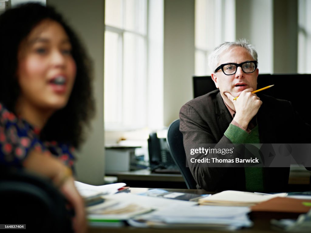 Coworkers having team project discussion in office