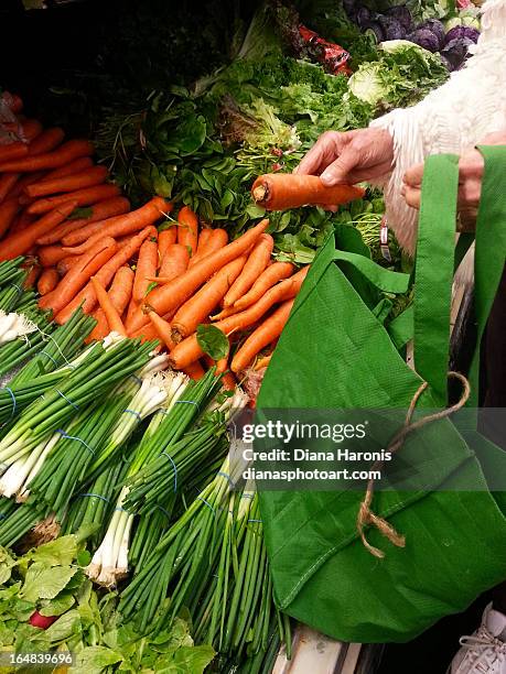 woman choosing carrots - huntington beach market stock-fotos und bilder