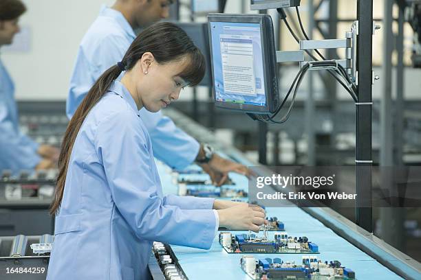 woman works on circuit board on conveyor belt - production line imagens e fotografias de stock