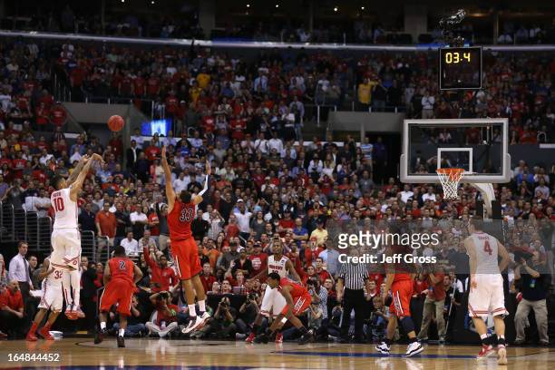 LaQuinton Ross of the Ohio State Buckeyes makes a three-pointer over Grant Jerrett of the Arizona Wildcats in the final seconds during the West...