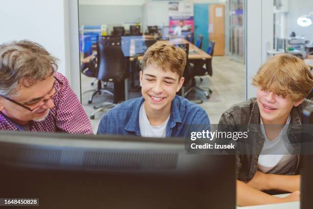 two high school students talling with teacher during coding lesson - computer lab kids stock pictures, royalty-free photos & images