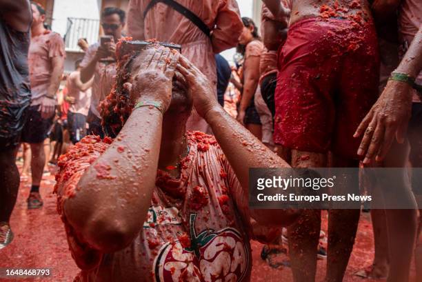 Young girl covered with tomato during the festival of La Tomatina, on 30 August, 2023 in Buñol, Valencia, Valencian Community, Spain. La Tomatina has...