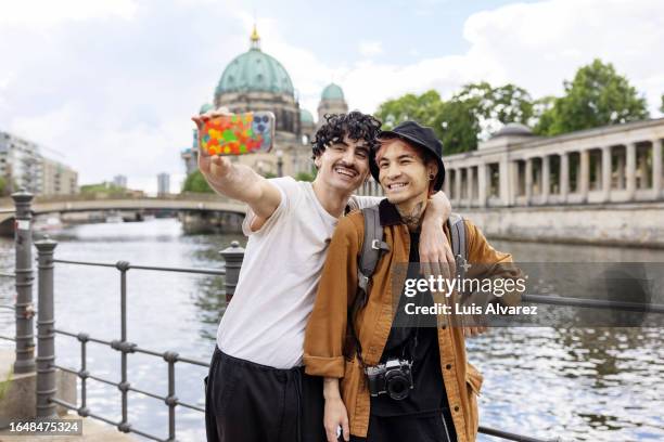 happy gay couple taking selfie with berlin cathedral in background - mitte stock pictures, royalty-free photos & images