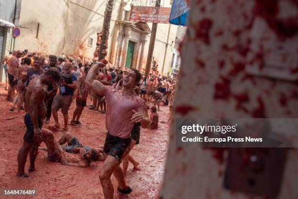 Several people covered with tomato during the festival of La Tomatina, on 30 August, 2023 in Buñol, Valencia, Valencian Community, Spain. La Tomatina...