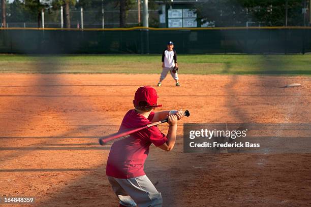 rear view of a boy preparing to swing a bat on baseball diamond - bass player bildbanksfoton och bilder