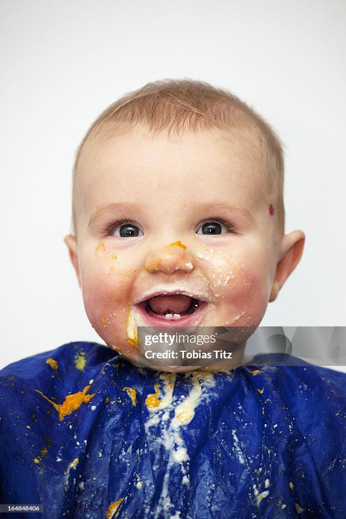 Portrait of a happy baby boy covered in food