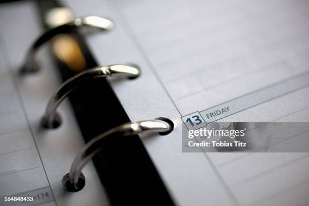 detail of a diary opened on friday the 13th - fridy stock pictures, royalty-free photos & images