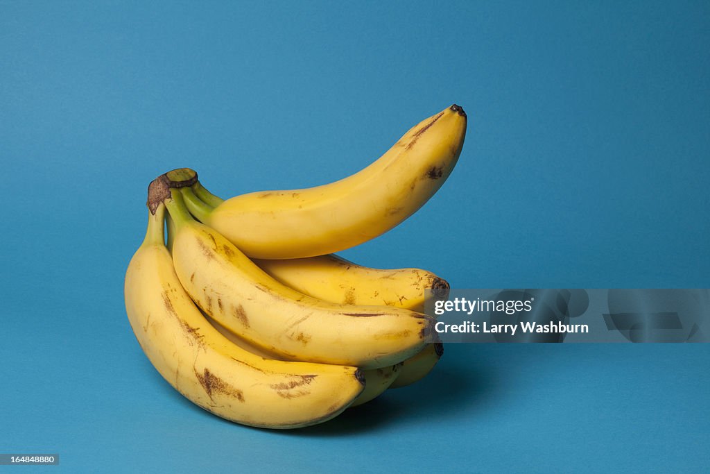 A bunch of bananas with one banana sticking up, suggestive of an erection