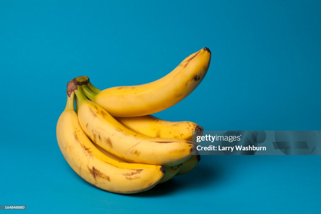A bunch of bananas with one banana sticking up, suggestive of an erection