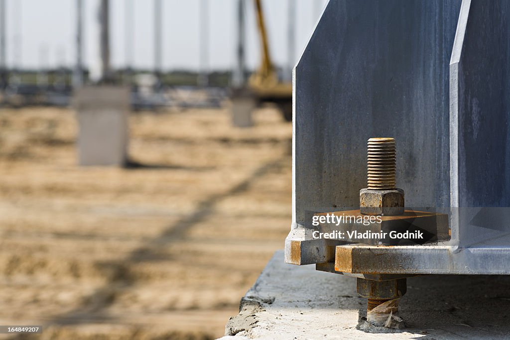 Large nut and bolt connected to beam in construction site