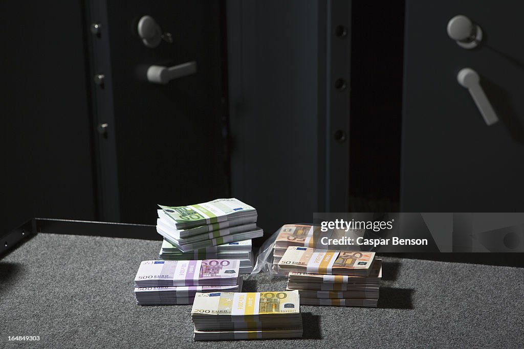 Stacks of large billed Euro banknotes on a table outside of a vault