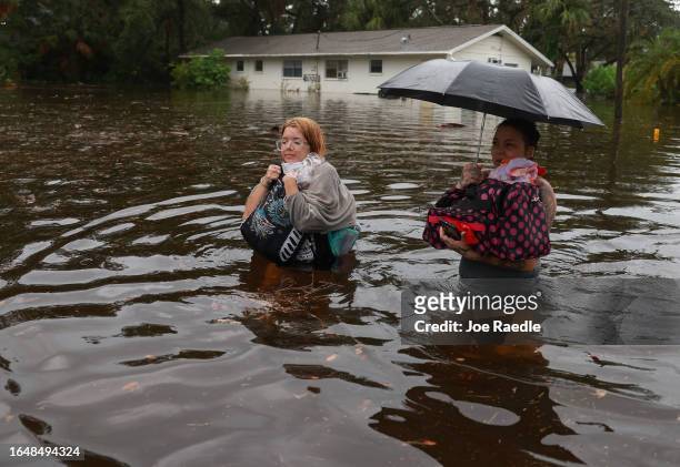 Makatla Ritchter and her mother, Keiphra Line wade through flood waters after having to evacuate their home when the flood waters from Hurricane...