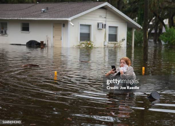 Makatla Ritchter wades through flood waters after having to evacuate her home when the flood waters from Hurricane Idalia inundated it on August 30,...