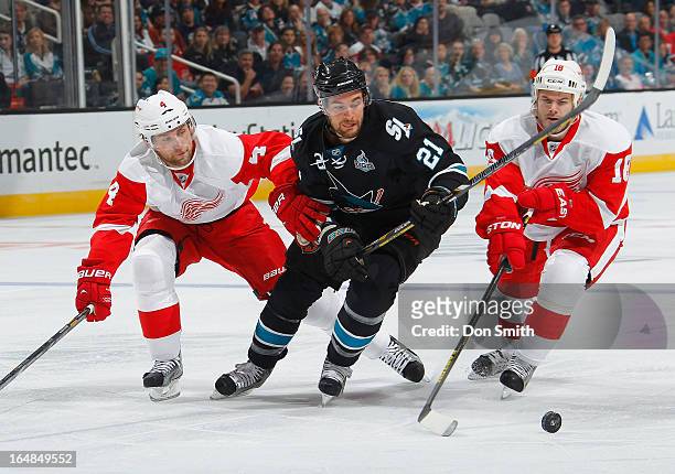 Galiardi of the San Jose Sharks battles for the puck against Jakub Kindl and Ian White of the Detroit Red Wings during an NHL game on March 28, 2013...