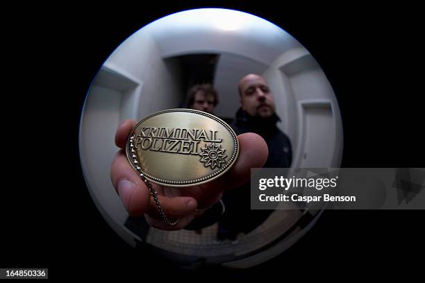 two detectives showing a crime police (german: kriminal polizei) badge to a peephole - kikhål bildbanksfoton och bilder