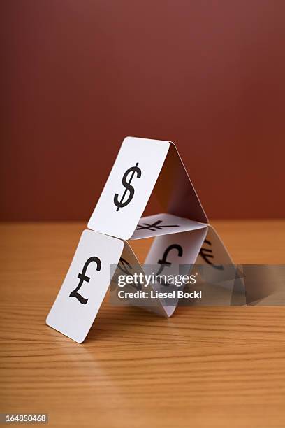 a house of cards of various currency - house of cards stock pictures, royalty-free photos & images