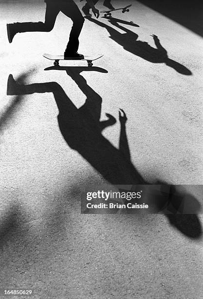 silhouetted skateboarders - figure skater stockfoto's en -beelden