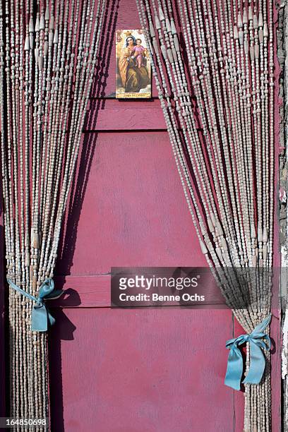 a holy card with the virgin mary and the baby jesus hanging on a door with beaded curtains - jesus christ photo stock pictures, royalty-free photos & images