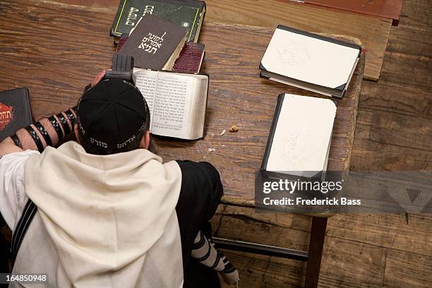 jewish man with tefillin reading religious prayer book - téphillin photos et images de collection