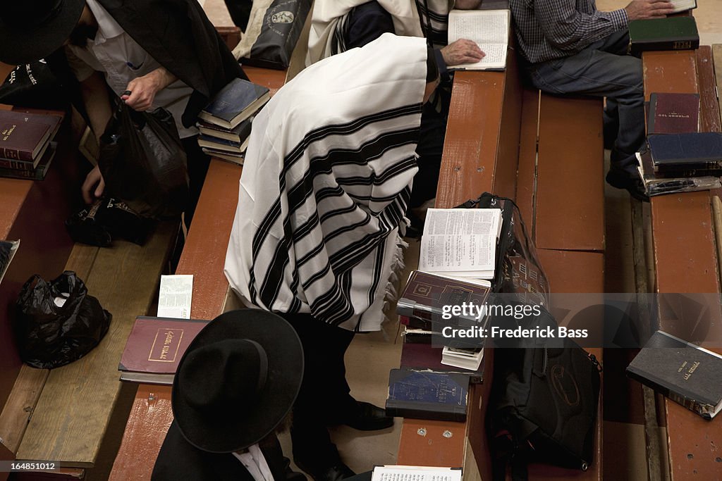 Jewish men in traditional clothing reading religious text