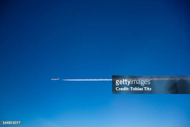 a plane and vapor trails in the sky - rastro de avião - fotografias e filmes do acervo