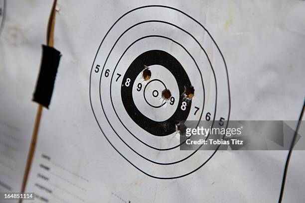 bullet holes on a paper target - off target stockfoto's en -beelden
