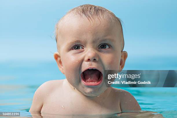 unhappy baby in water - first exposure series stock pictures, royalty-free photos & images