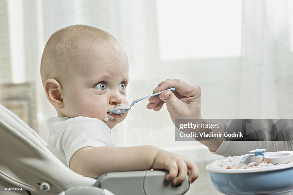 Mother spoon feeding her baby