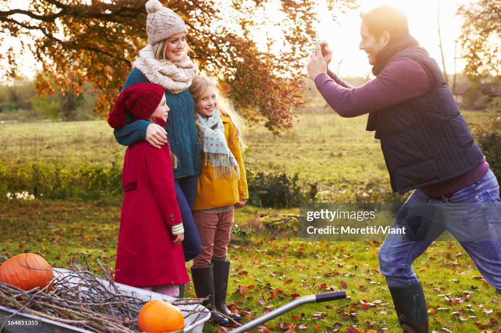 Father taking picture of family outdoors