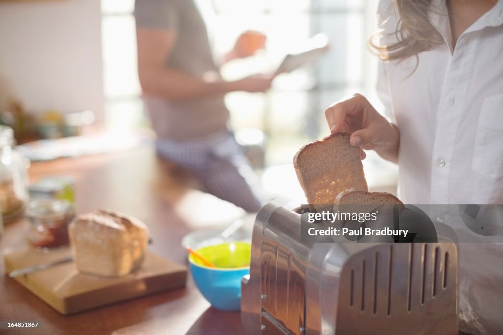 Frau putting-Brot in toaster