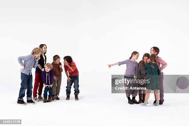 a group of boys laughing while a group of girls gossips about them - haciendo burla fotografías e imágenes de stock