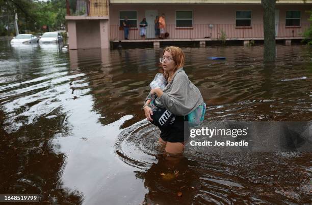 Makatla Ritchter wades through flood waters after having to evacuate her home when the flood waters from Hurricane Idalia inundated it on August 30,...