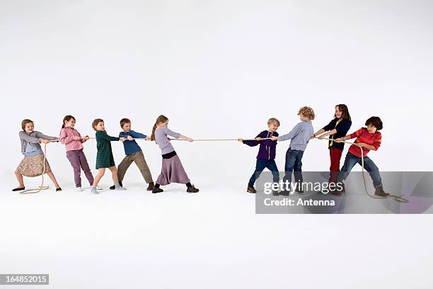 a group of kids playing tug-of-war - arrastar imagens e fotografias de stock