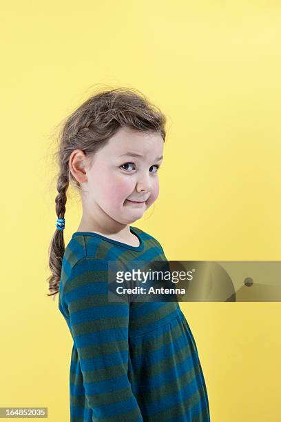 a girl looking mischievously into the camera - cheeky expression stock-fotos und bilder