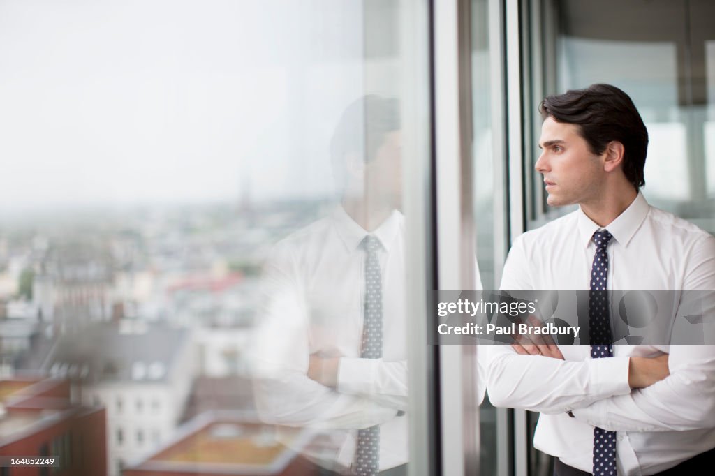 Businessman looking out office window