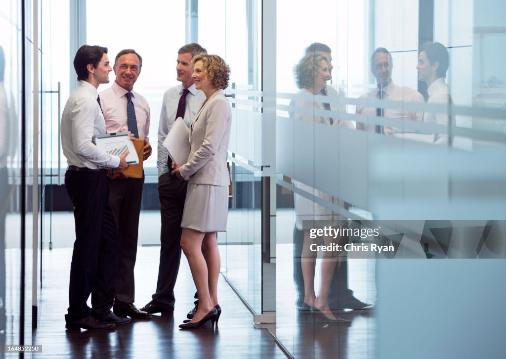 Business people talking in office hallway