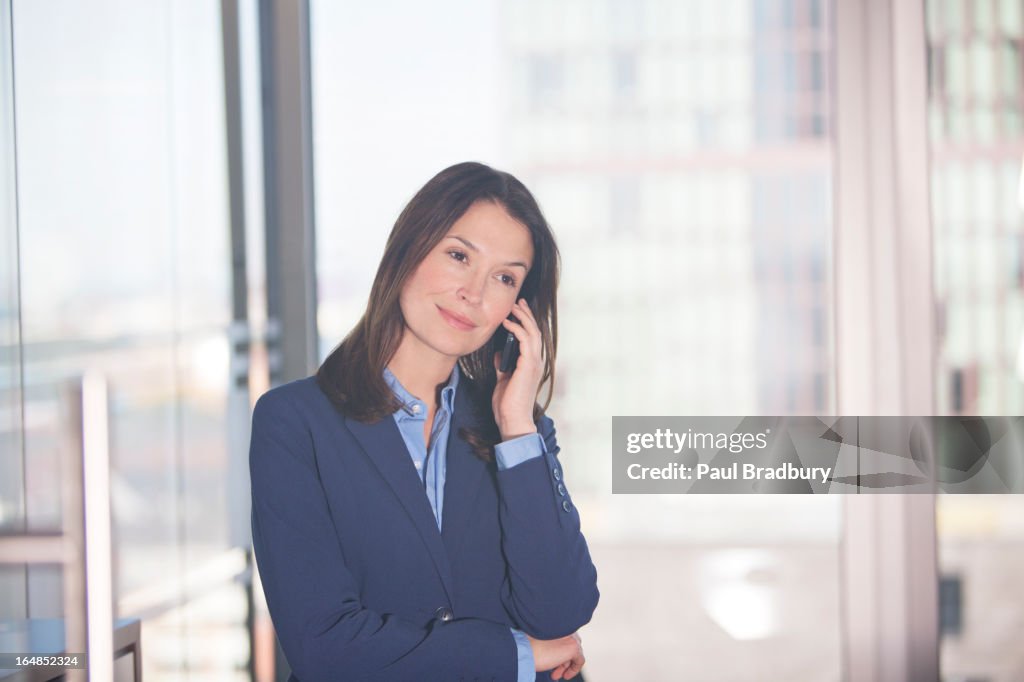 Businesswoman talking on cell phone in office