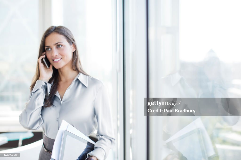 Businesswoman talking on cell phone in office