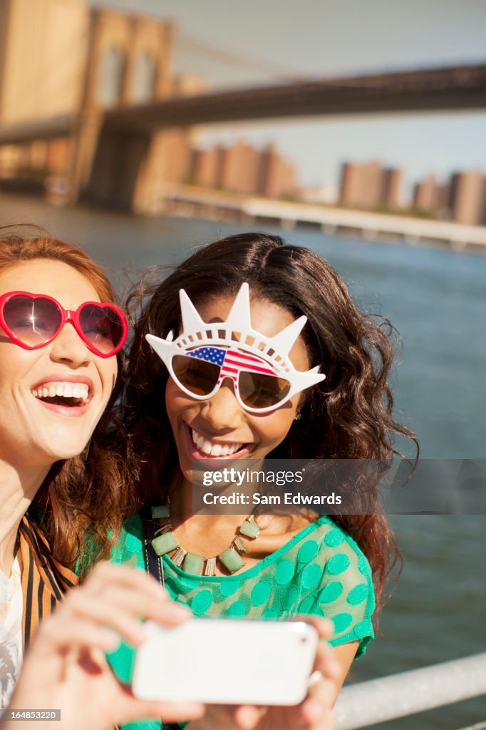 Mujeres en gafas de disfraz tomando imagen de la ciudad, paisaje de la ciudad