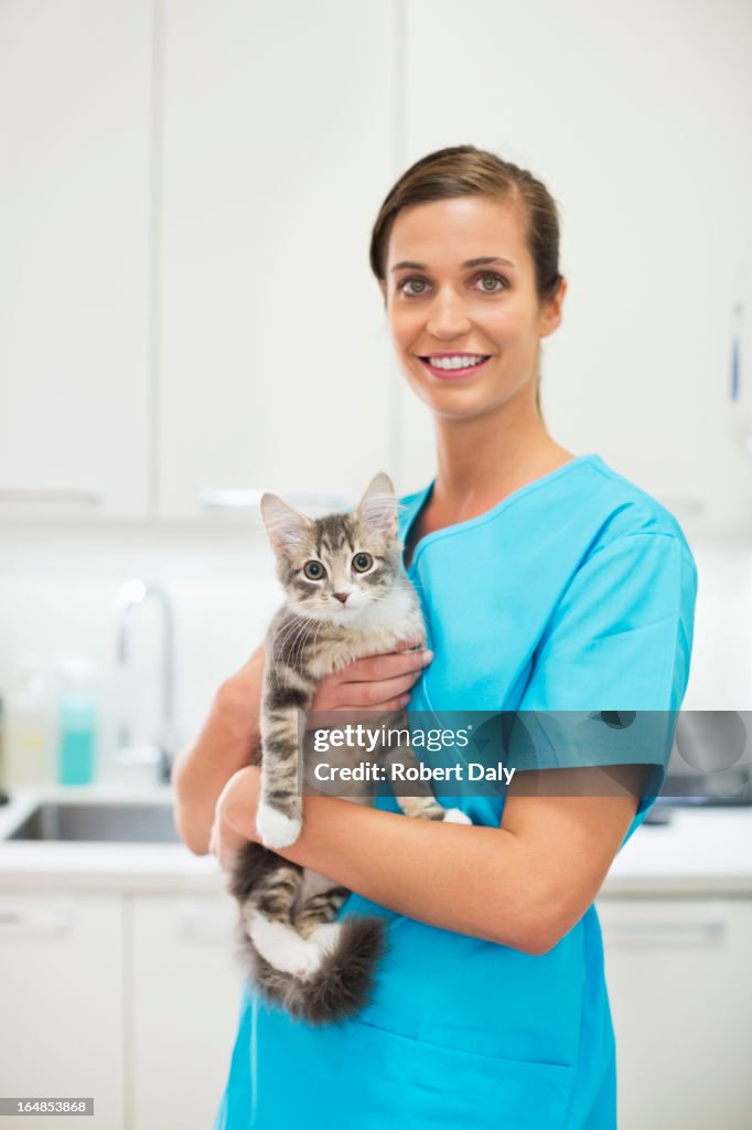 Smiling Veterinarian holding cat in vet's surgery