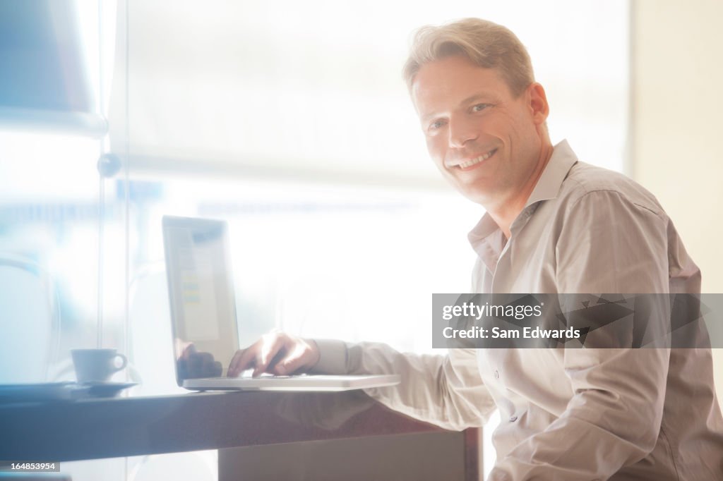 Businessman smiling at laptop