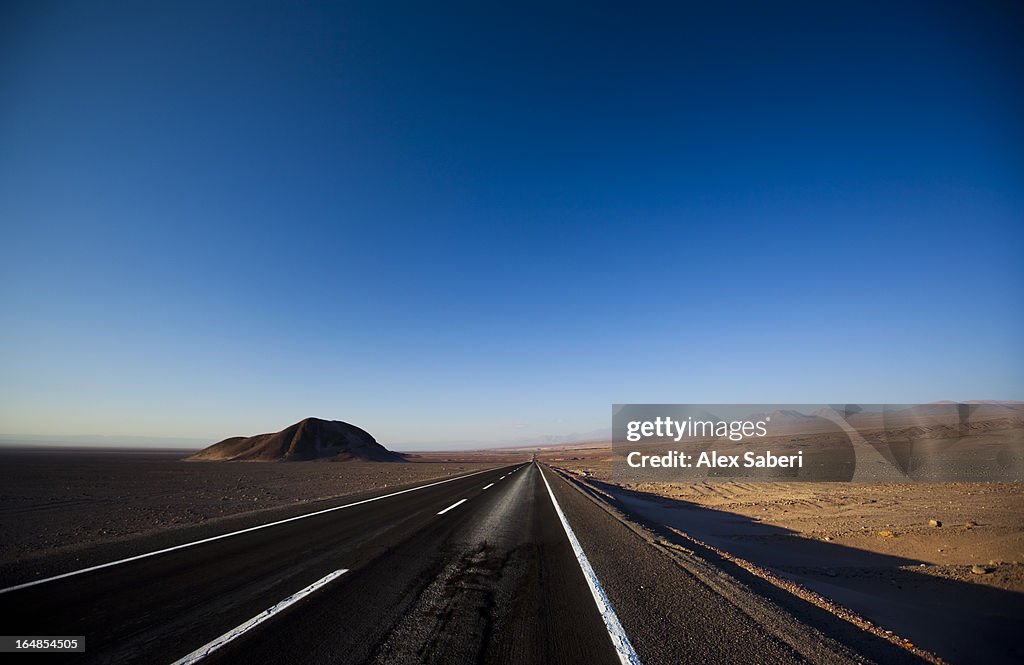 Volcanoes and a road in the Atacama Desert at sunset.