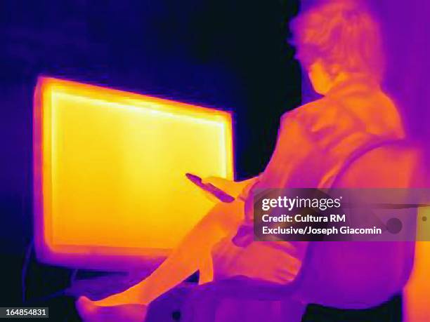 thermal image of woman and television - glow rm fotografías e imágenes de stock