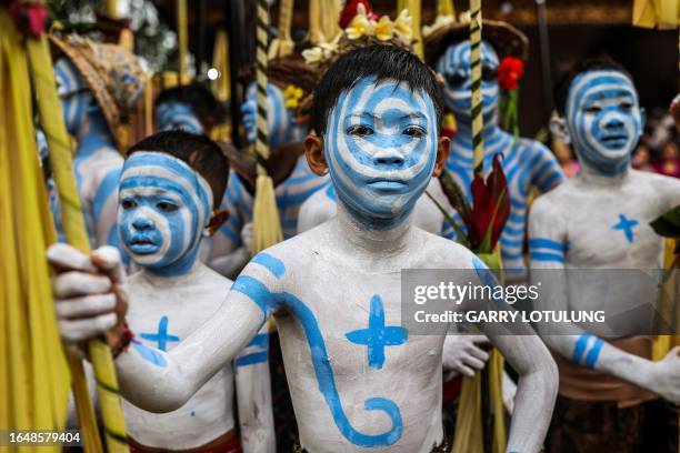 Boys body-painted as scary mythical creatures symbolizing the balance between darkness and light wait to practice their Hindu ritual, the Ngerebeg...