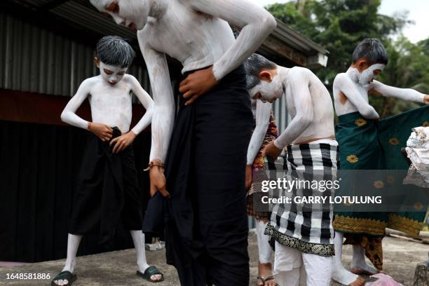 Body-painted children wear cloths as scary mythical creatures symbolizing the balance between darkness and light to practice their Hindu ritual, the...