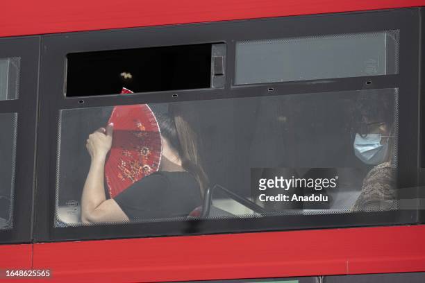 Woman, holding a hand fan, is seen on the bus during the hot weather in London, United Kingdom on September 06, 2023. The British Meteorological...