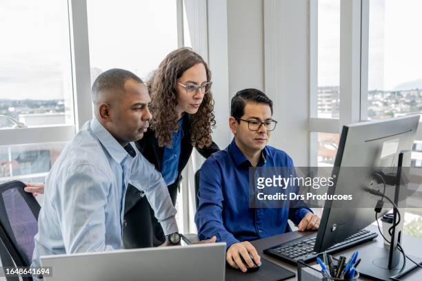 cybersecurity team discussing in front of a monitor screen - exibição bildbanksfoton och bilder