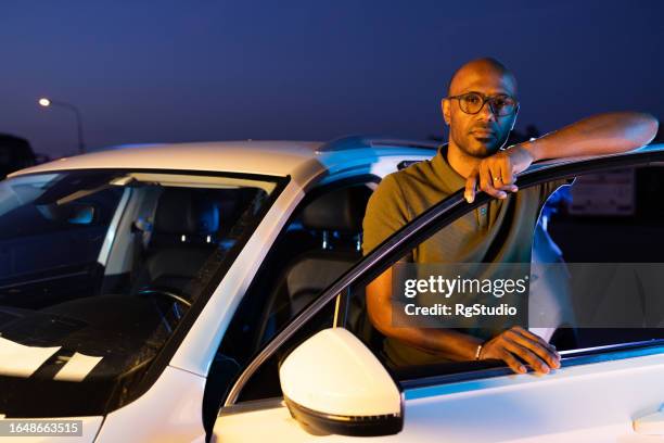portrait of a handsome man by his car - taxi driver stock pictures, royalty-free photos & images