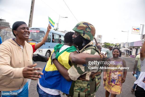 Joyful Gabonese embracing a Republican Guard soldier in front of the presidency in Port-Gentil , on August 30, 2023 after the announcement of the...