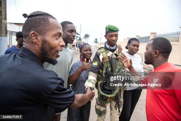 Joyful group of Gabonese embracing a Republican Guard soldier, in Port-Gentil , on August 30, 2023 after the announcement of the Coup d'Etat...